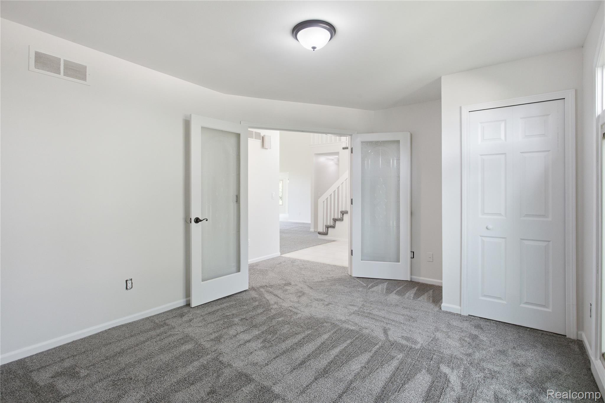 52658 Stag Ridge Drive Macomb, MI 48042 - Photo 17 of 28 Room featuring light gray patterned carpeting, white walls, and a semi-flush mount ceiling light