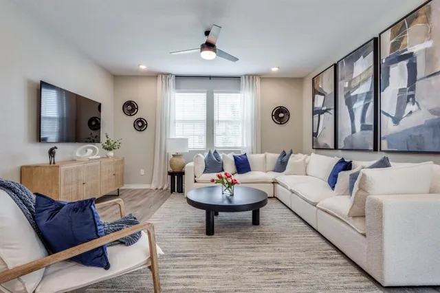 a living room with furniture a flat screen tv and a large window
