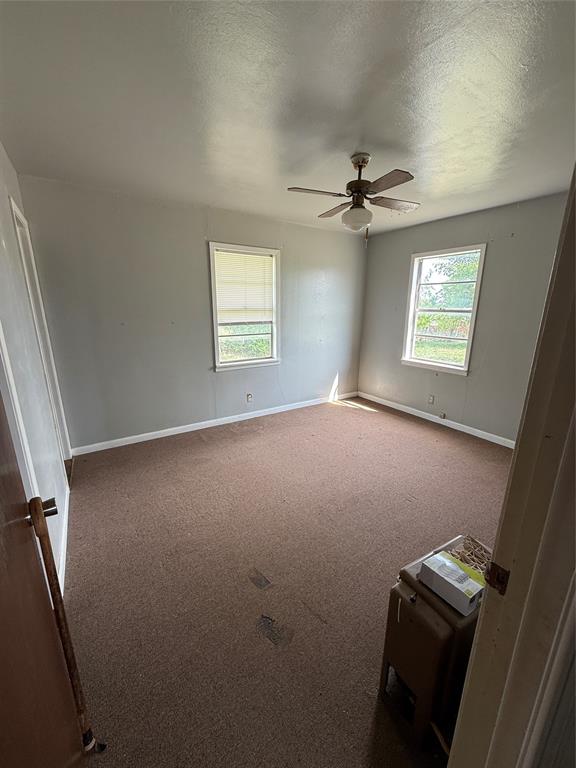 701 Perry Street Santa Anna, TX 76878 - Photo 12 of 13 an empty room with windows and fan