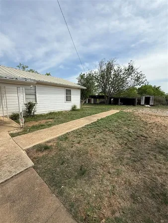 a view of a house with a yard and street