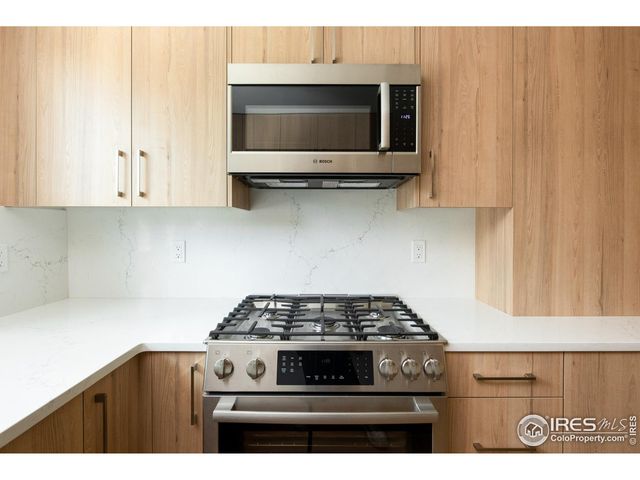 a kitchen with stainless steel appliances granite countertop a stove and a microwave