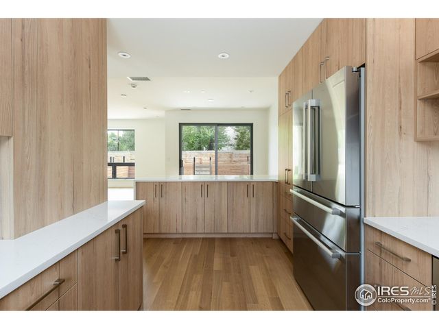 a kitchen with stainless steel appliances a refrigerator and a window