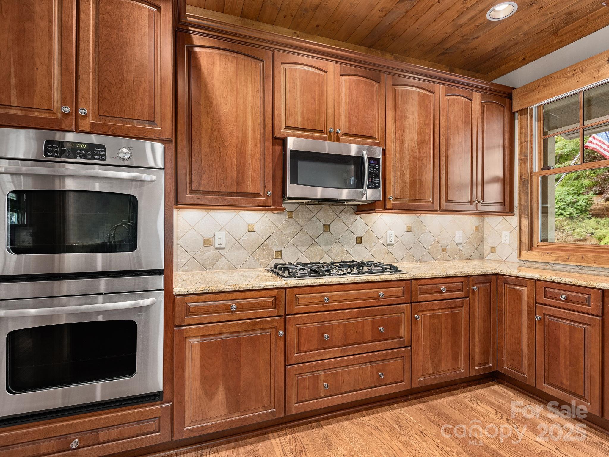 120 Mossy Rock Road Sapphire, NC 28774 - Photo 13 of 47 a kitchen with granite countertop a stove microwave and sink