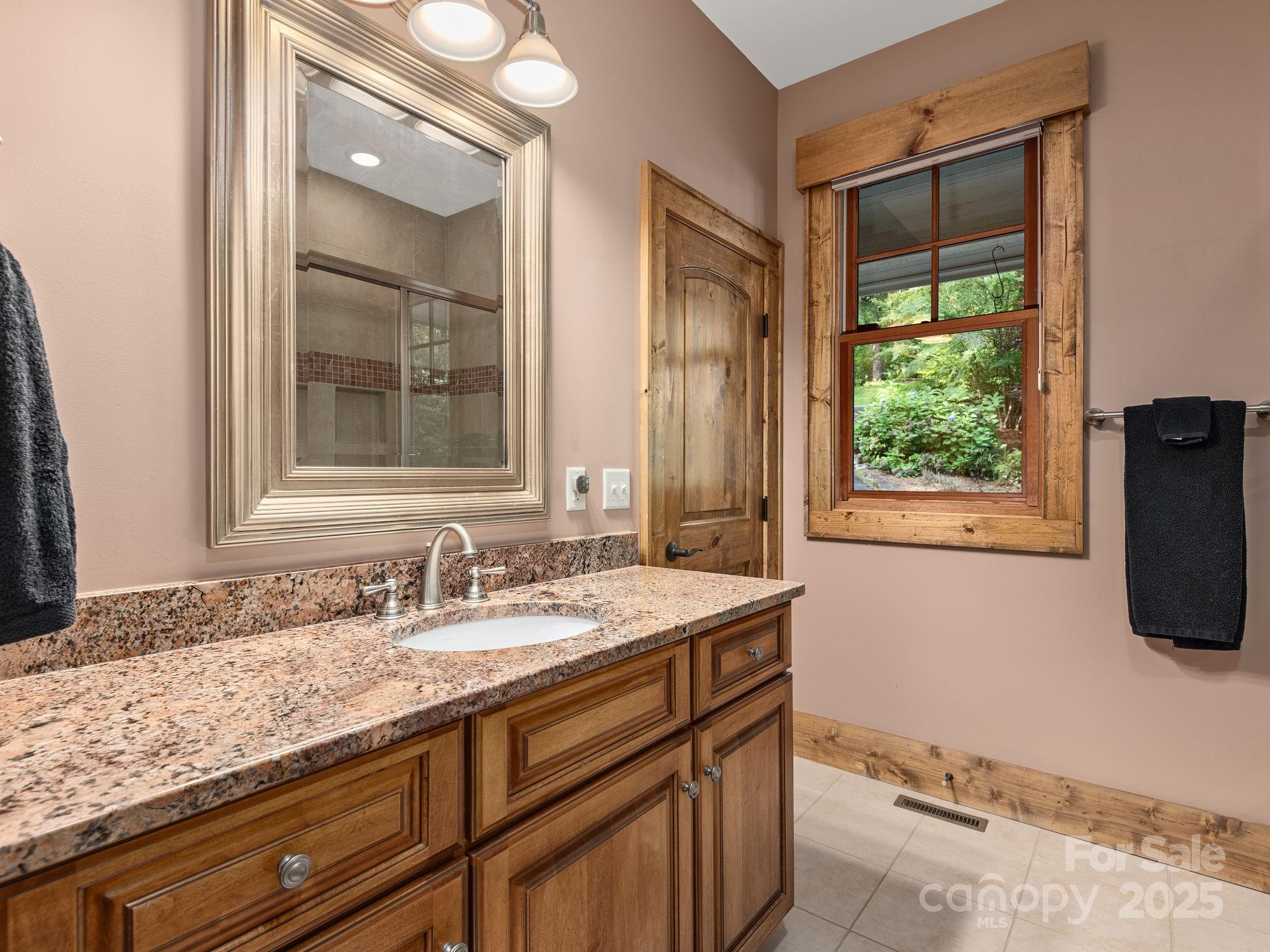120 Mossy Rock Road Sapphire, NC 28774 - Photo 29 of 47 a bathroom with a granite countertop sink and a window