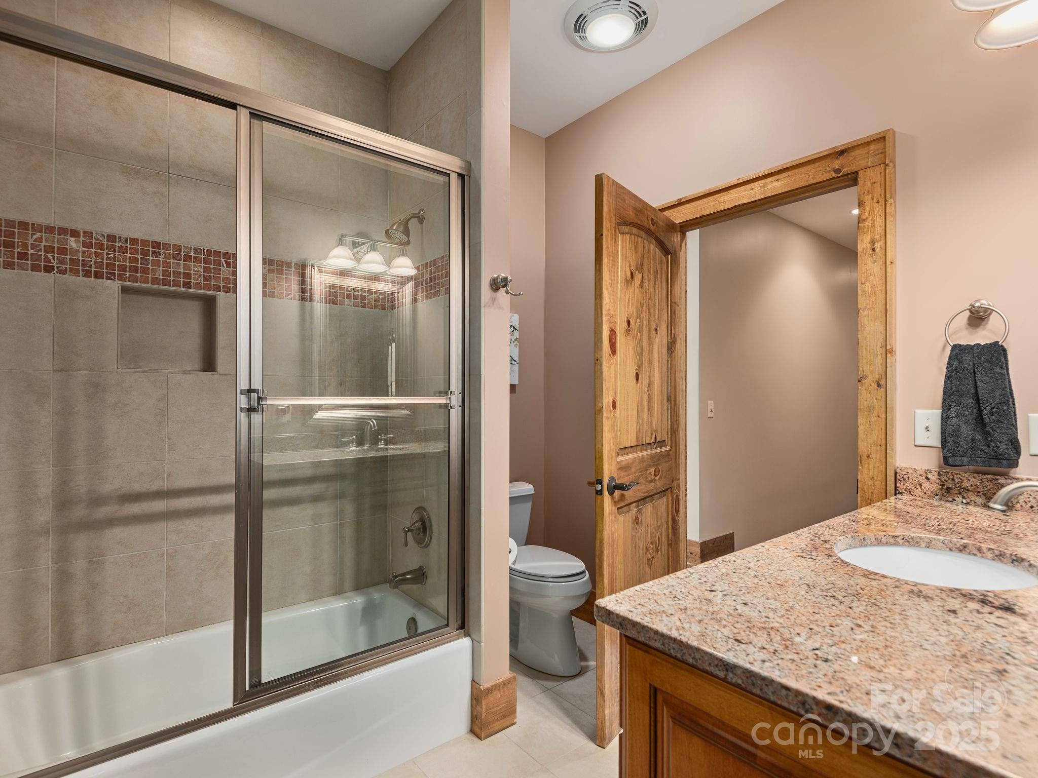 120 Mossy Rock Road Sapphire, NC 28774 - Photo 30 of 47 a bathroom with a granite countertop sink toilet and shower