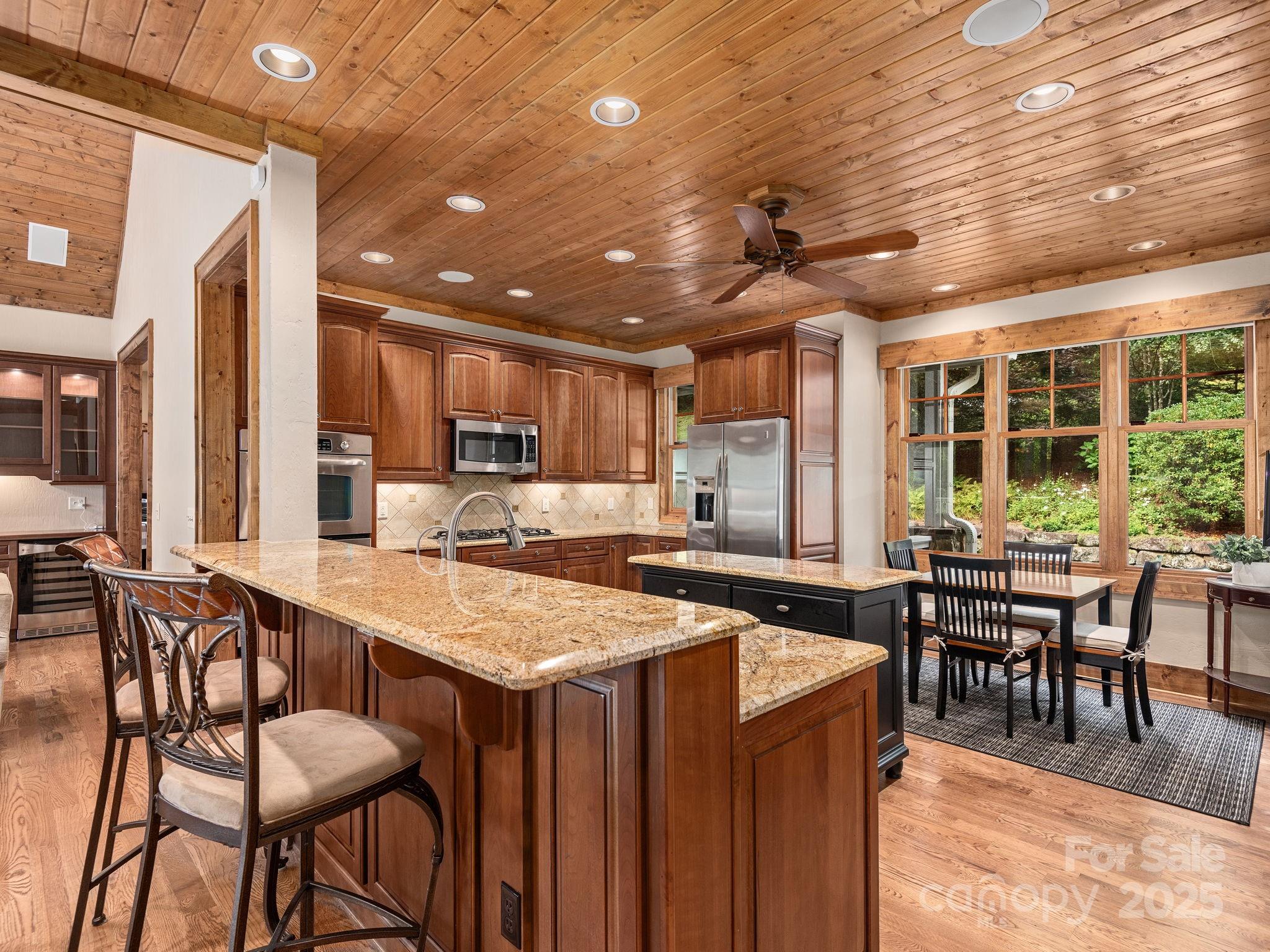 120 Mossy Rock Road Sapphire, NC 28774 - Photo 10 of 47 a dining hall with stainless steel appliances granite countertop a table chairs and a chandelier