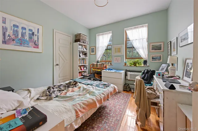 a bedroom with a bed a large window and book self