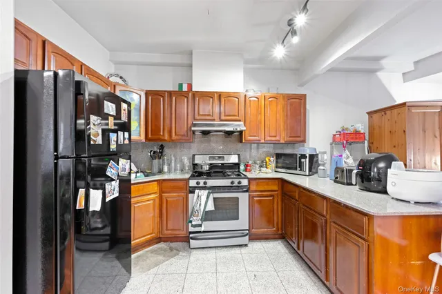 a kitchen with stainless steel appliances granite countertop a refrigerator stove and sink