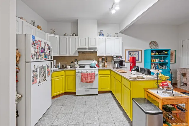 a view of a kitchen with fridge and workspace