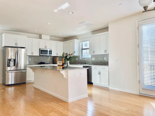 a kitchen with stainless steel appliances a refrigerator sink and microwave