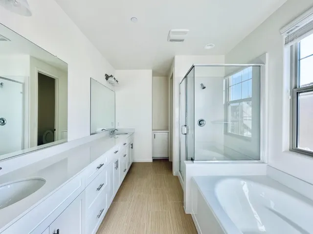 a spacious bathroom with a tub sink shower and mirror