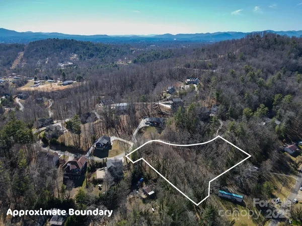 an aerial view of a residential house and mountain view