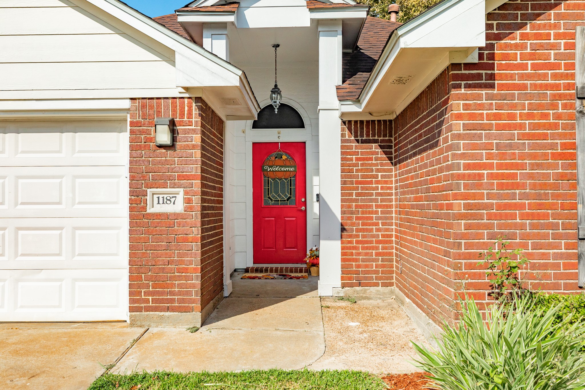 1187 Thomas Drive Angleton, TX 77515 - Photo 3 of 24 a view of a brick house with a small yard and wooden wall