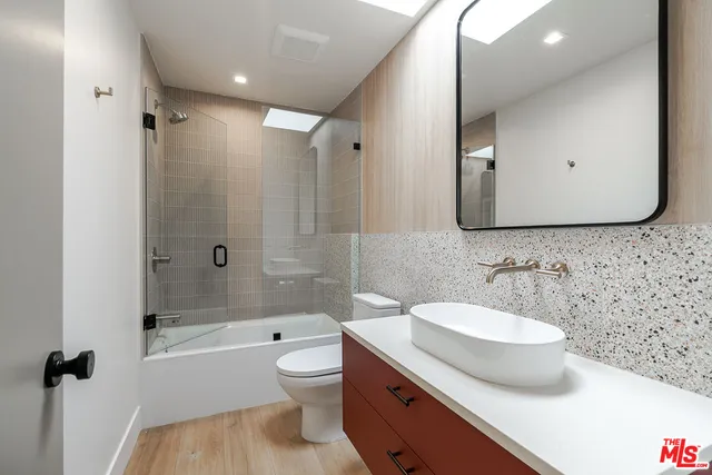 a bathroom with a sink a toilet and shower