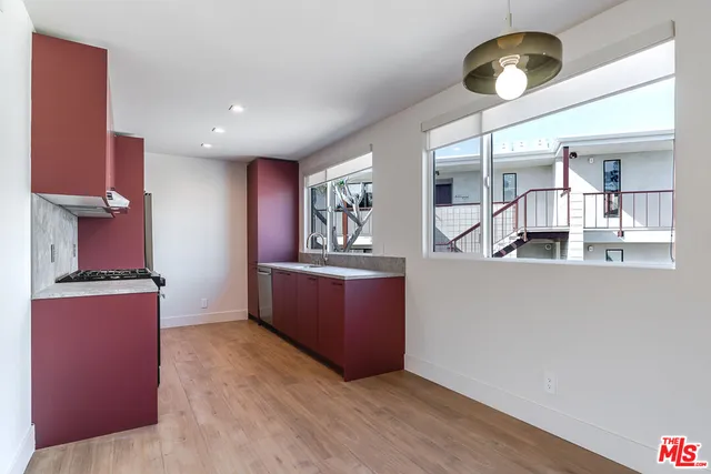 a kitchen with stainless steel appliances granite countertop a stove and a wooden floors