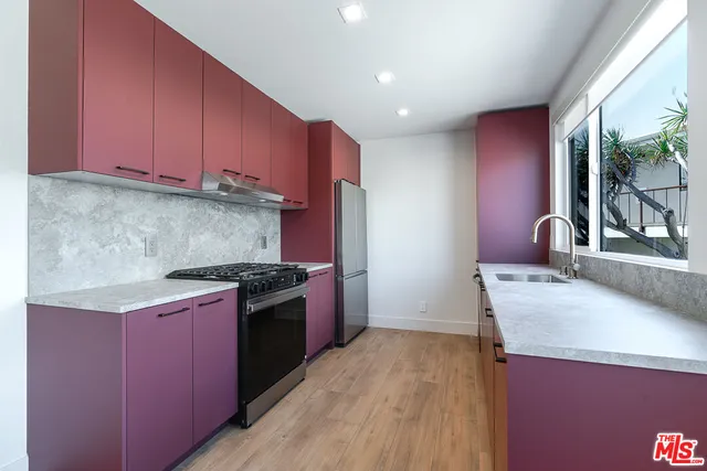 a kitchen with stainless steel appliances granite countertop a stove a sink and a refrigerator