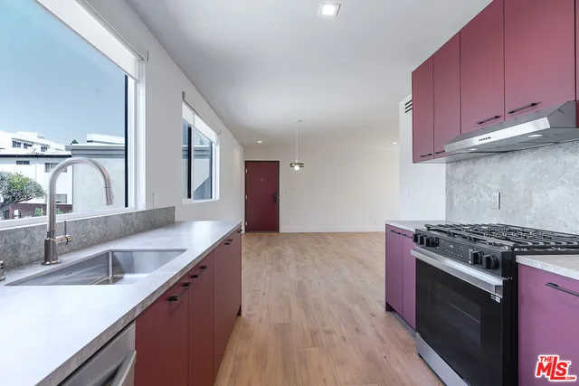 a kitchen with granite countertop a sink stove and cabinets