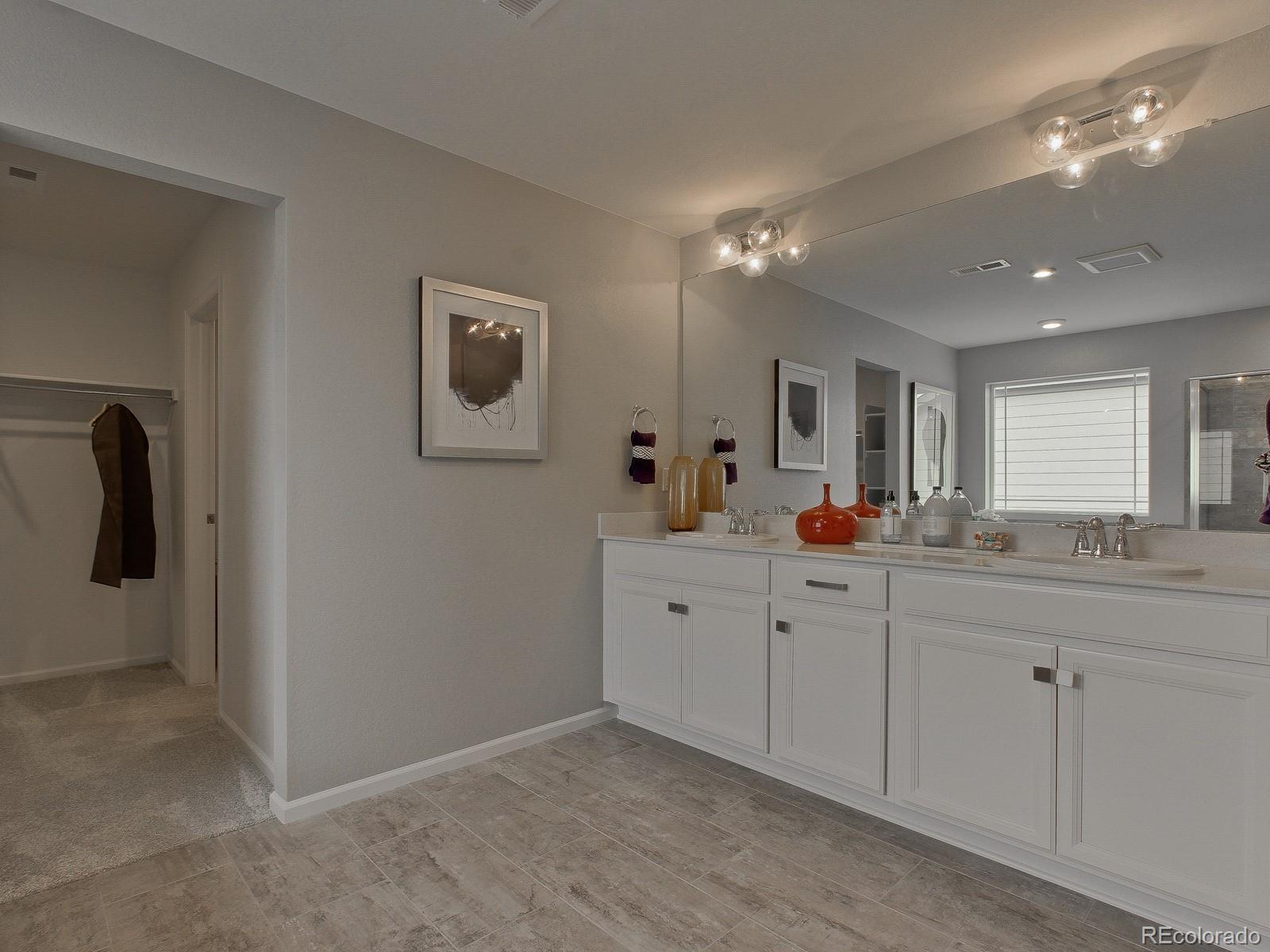 9196 Rifle Street Commerce City, CO 80022 - Photo 27 of 40 a spacious bathroom with a double vanity sink and mirror