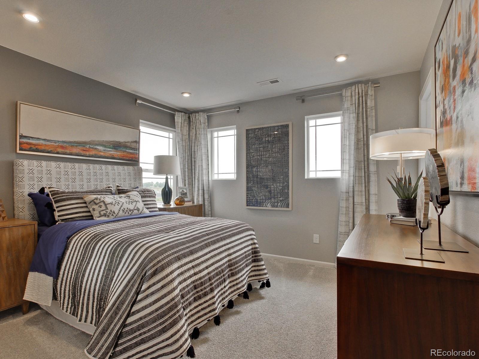 9196 Rifle Street Commerce City, CO 80022 - Photo 31 of 40 a bedroom with a bed and dresser with mirror