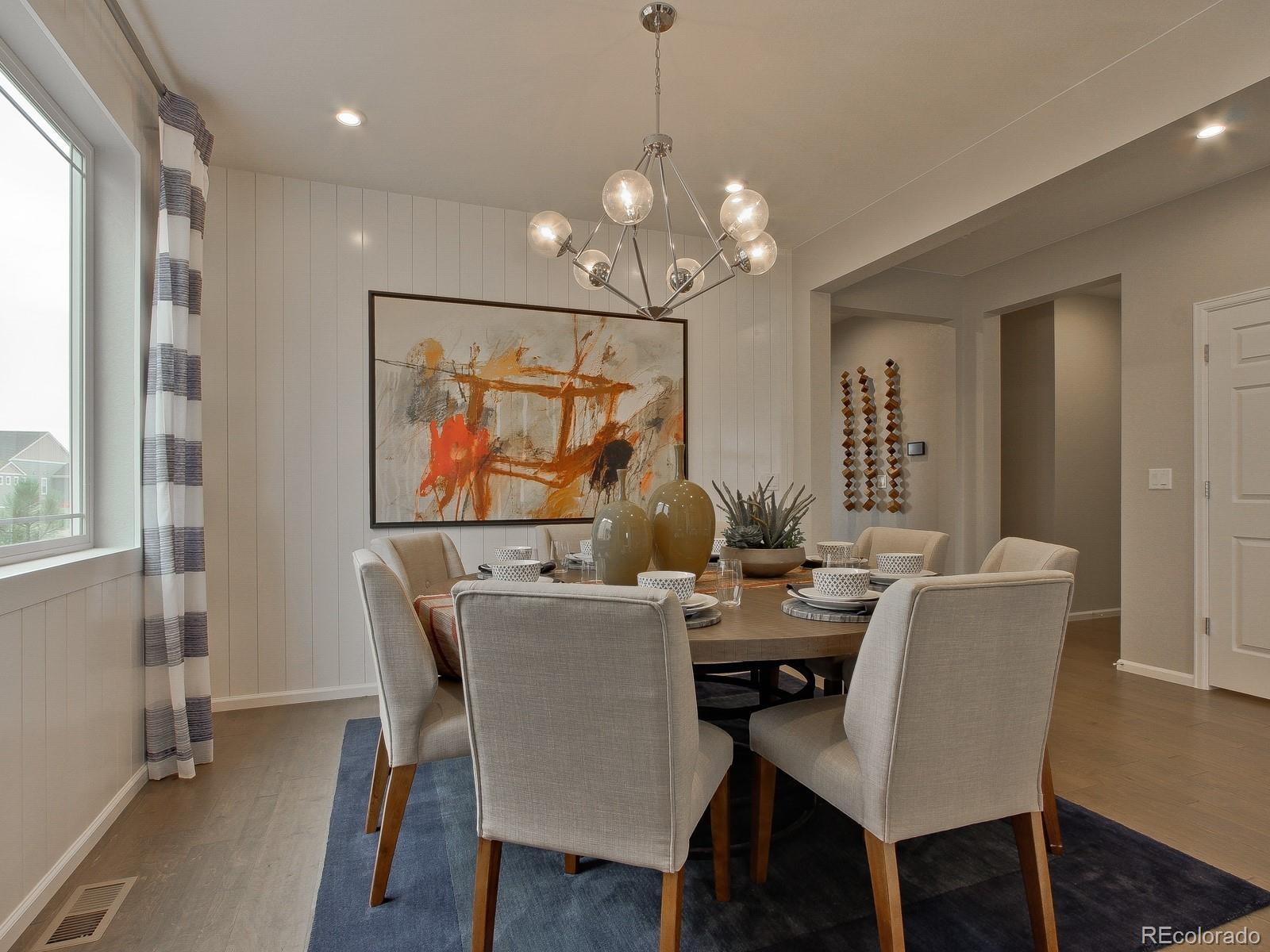9196 Rifle Street Commerce City, CO 80022 - Photo 6 of 40 a dining room with furniture a chandelier and wooden floor