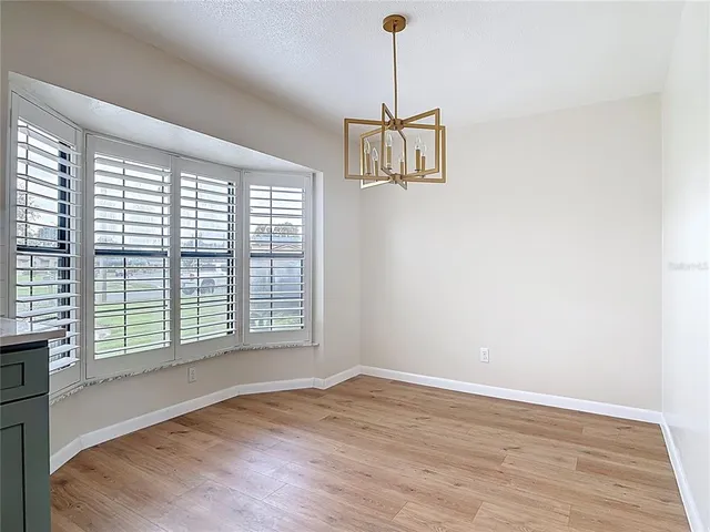 a view of a room with a window and wooden floor