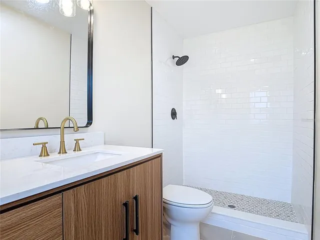 a bathroom with a sink a toilet and shower