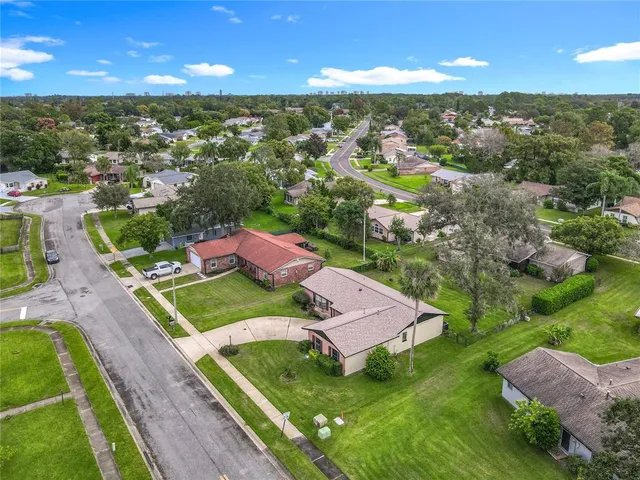 an aerial view of residential houses with outdoor space and trees