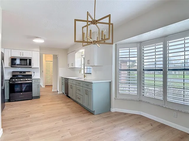 a kitchen with stainless steel appliances granite countertop a stove a sink and a microwave