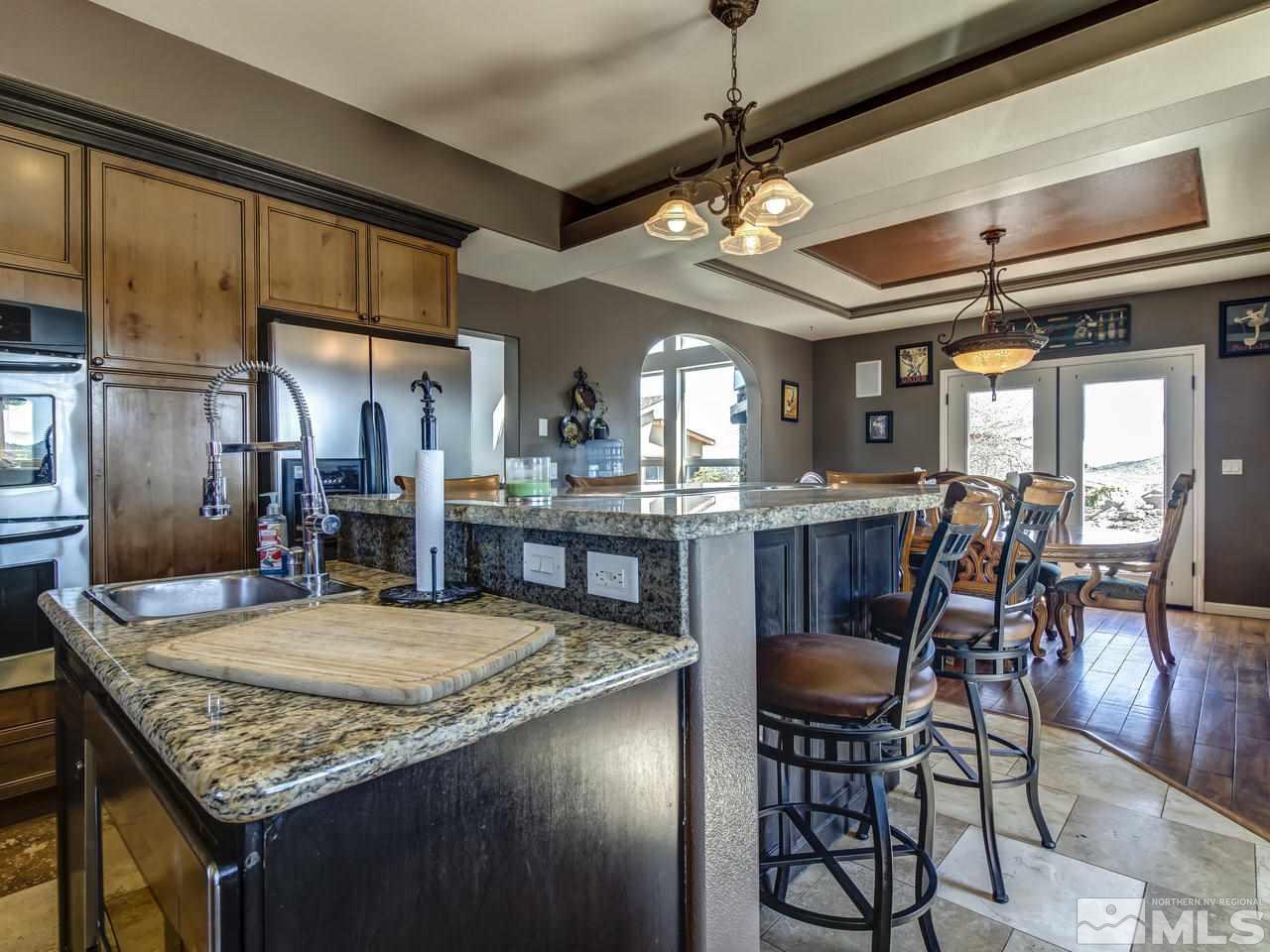 21575 Colt Drive Reno, NV 89521 - Photo 8 of 20 a kitchen with stainless steel appliances granite countertop a kitchen island a stove and a dining table with kitchen view