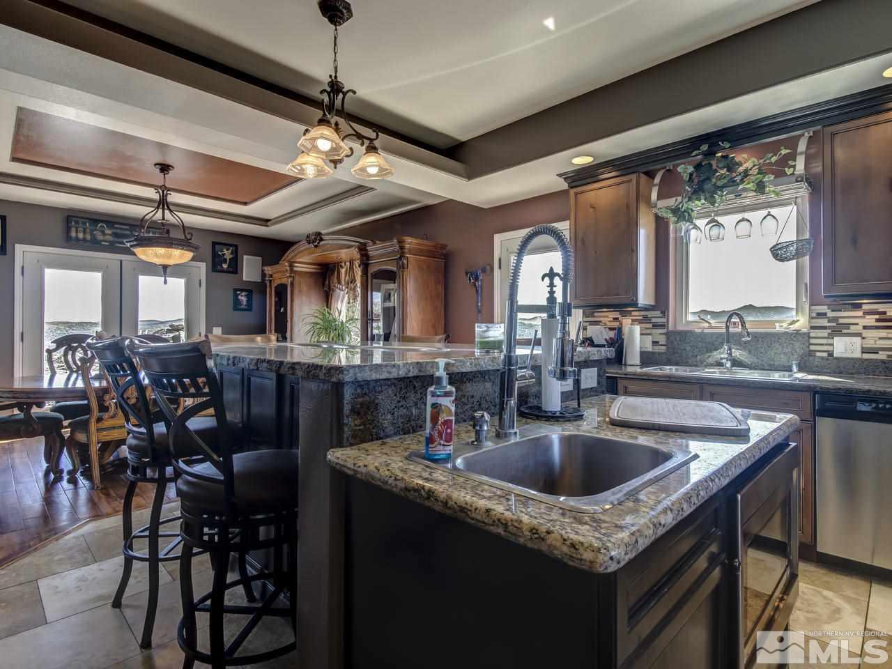 21575 Colt Drive Reno, NV 89521 - Photo 9 of 20 a kitchen with a sink a counter space appliances and a chandelier
