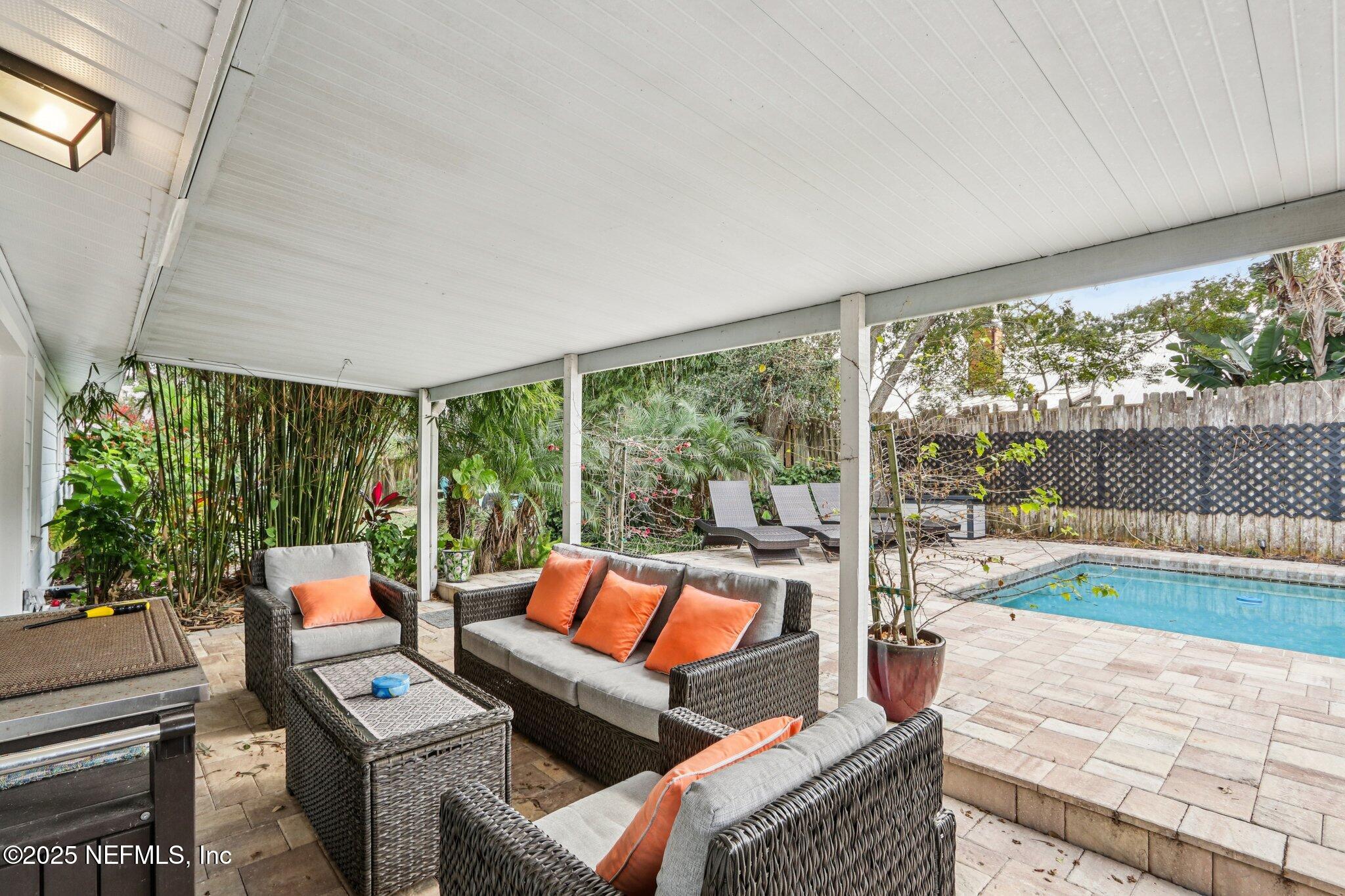 409 Seventeenth Street St. Augustine, FL 32084 - Photo 32 of 42 a living room with patio furniture and a large window