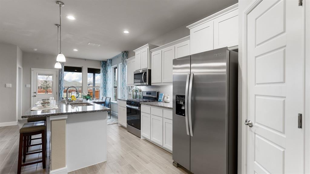 243 Windmill Drive Rhome, TX 76078 - Photo 2 of 39 a kitchen with stainless steel appliances a refrigerator sink and stove