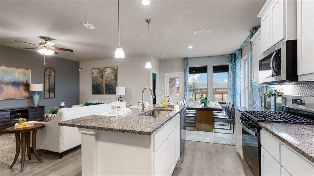 243 Windmill Drive Rhome, TX 76078 - Photo 5 of 39 a kitchen with center island a sink appliances and living room view