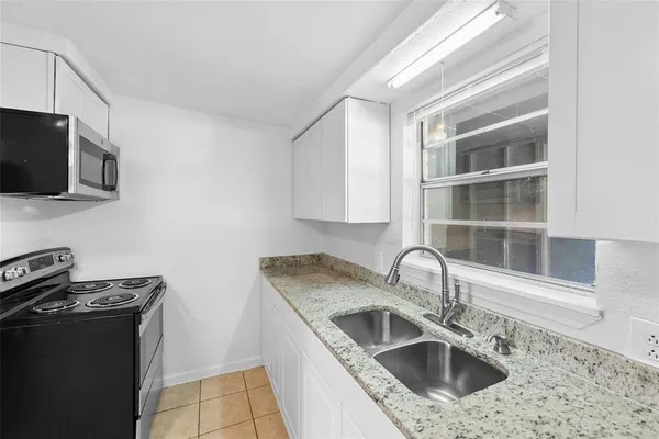a kitchen with stainless steel appliances granite countertop a sink and a stove