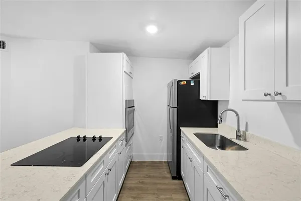 a kitchen with a sink a refrigerator and cabinets