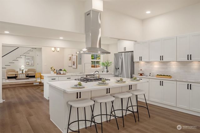 a kitchen with stainless steel appliances kitchen island granite countertop a sink and cabinets