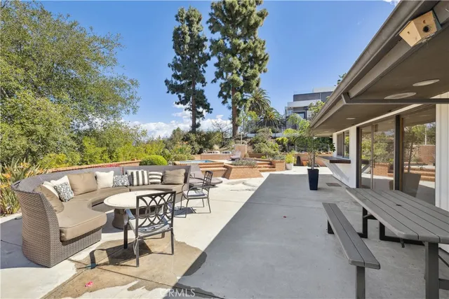a view of a patio with couches and table and chairs and potted plants