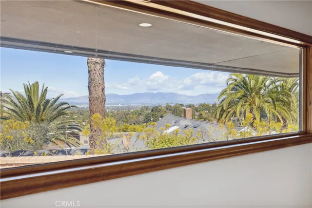 a view of a room with a large window and wooden floor