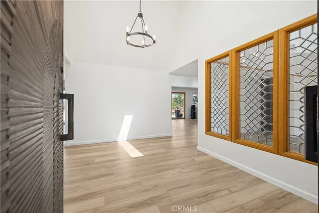 a view of an empty room with wooden floor and windows