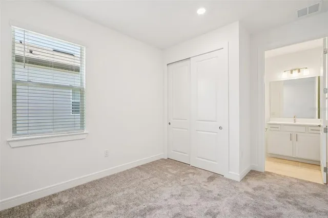 a bedroom with a large bed couch and a window