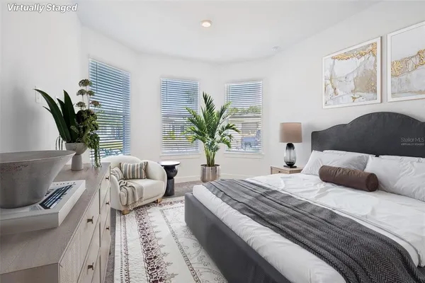 a bedroom with a large bed couch and a window