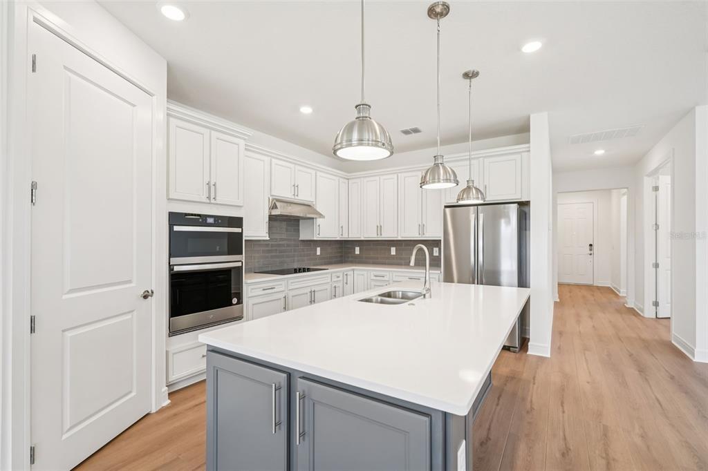 5236 Southwest 88th Circle Ocala, FL 34481 - Photo 8 of 29 a kitchen with a white center island a refrigerator and cabinets