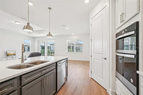 a kitchen with stainless steel appliances granite countertop a sink a oven and wooden floors
