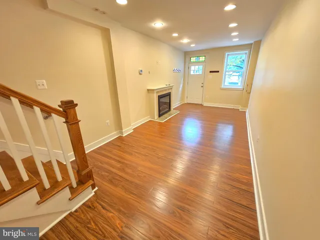 a view of a livingroom with wooden floor and staircase