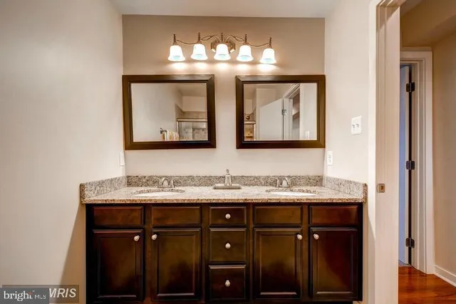 a bathroom with a double vanity sink and a mirror