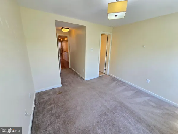 an empty room with a bathroom and mirror