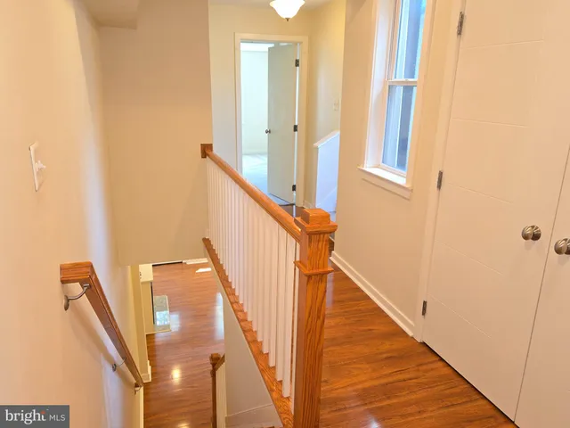 a view of staircase with railing and white walls