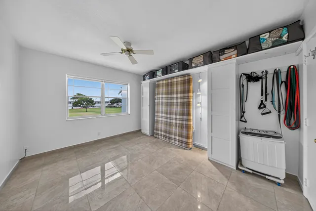 a bedroom with a large bed a flat tv screen and a chandelier