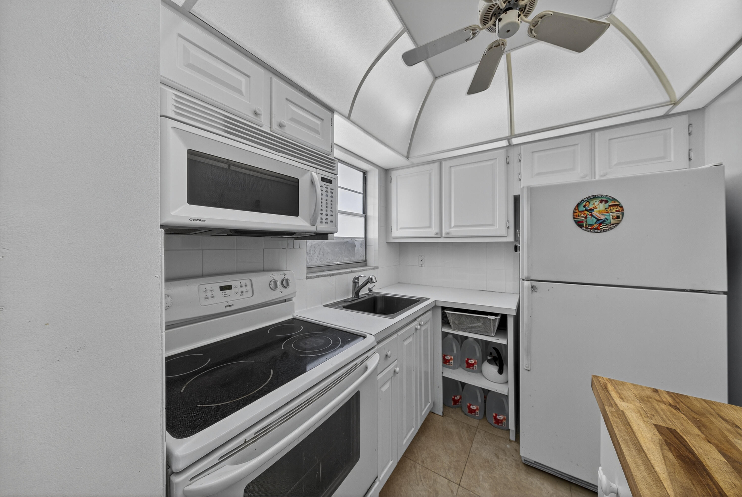 251 South Golf Boulevard, Unit 287 Pompano Beach, FL 33064 - Photo 3 of 63 a kitchen with stainless steel appliances a stove microwave and a refrigerator