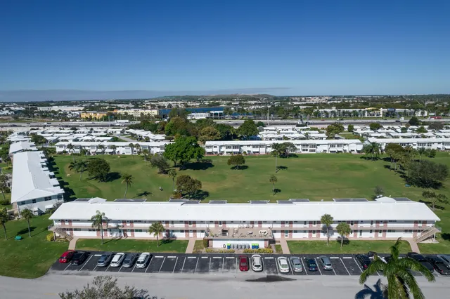a living room with furniture kitchen view and a wooden floor